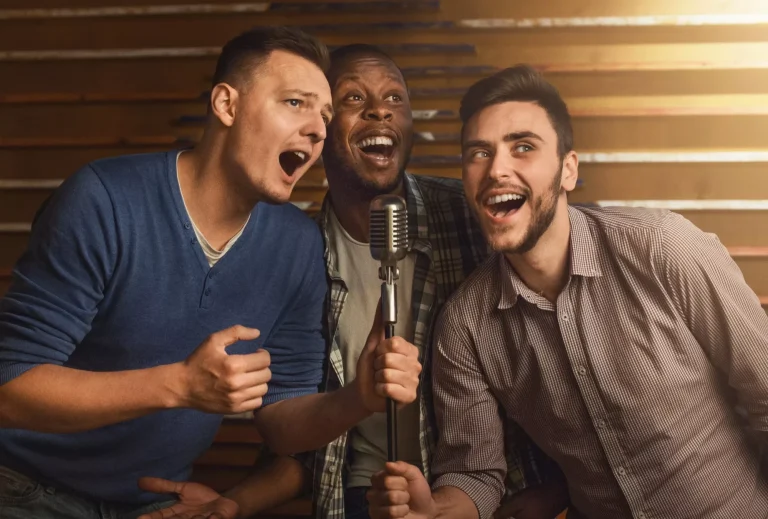 Glückliche Freunde singen zusammen Karaoke in einer Bar
