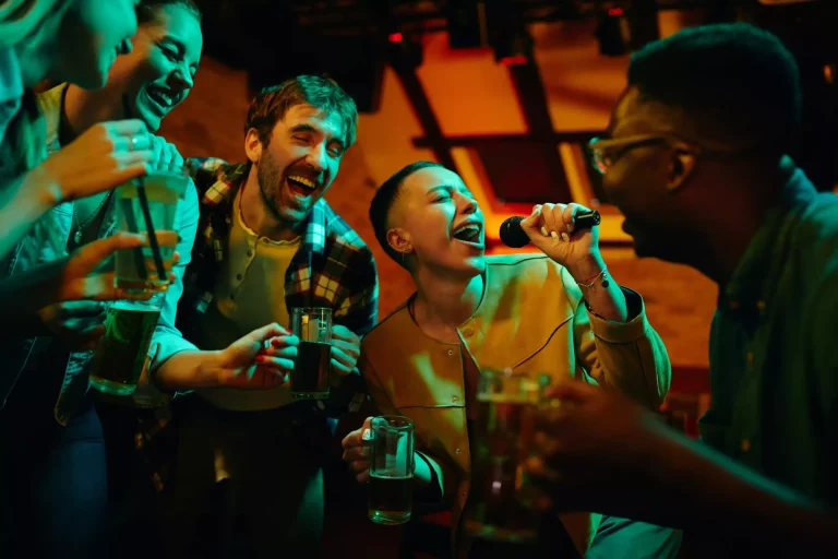 Fröhliche Freunde haben Spaß beim Karaoke-Singen in einer Kneipe.