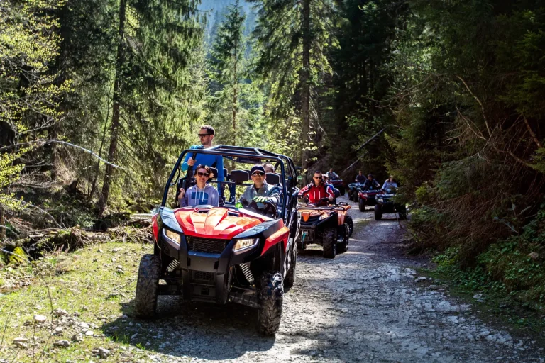 Un gruppo di turisti viaggia su ATV e UTV in montagna